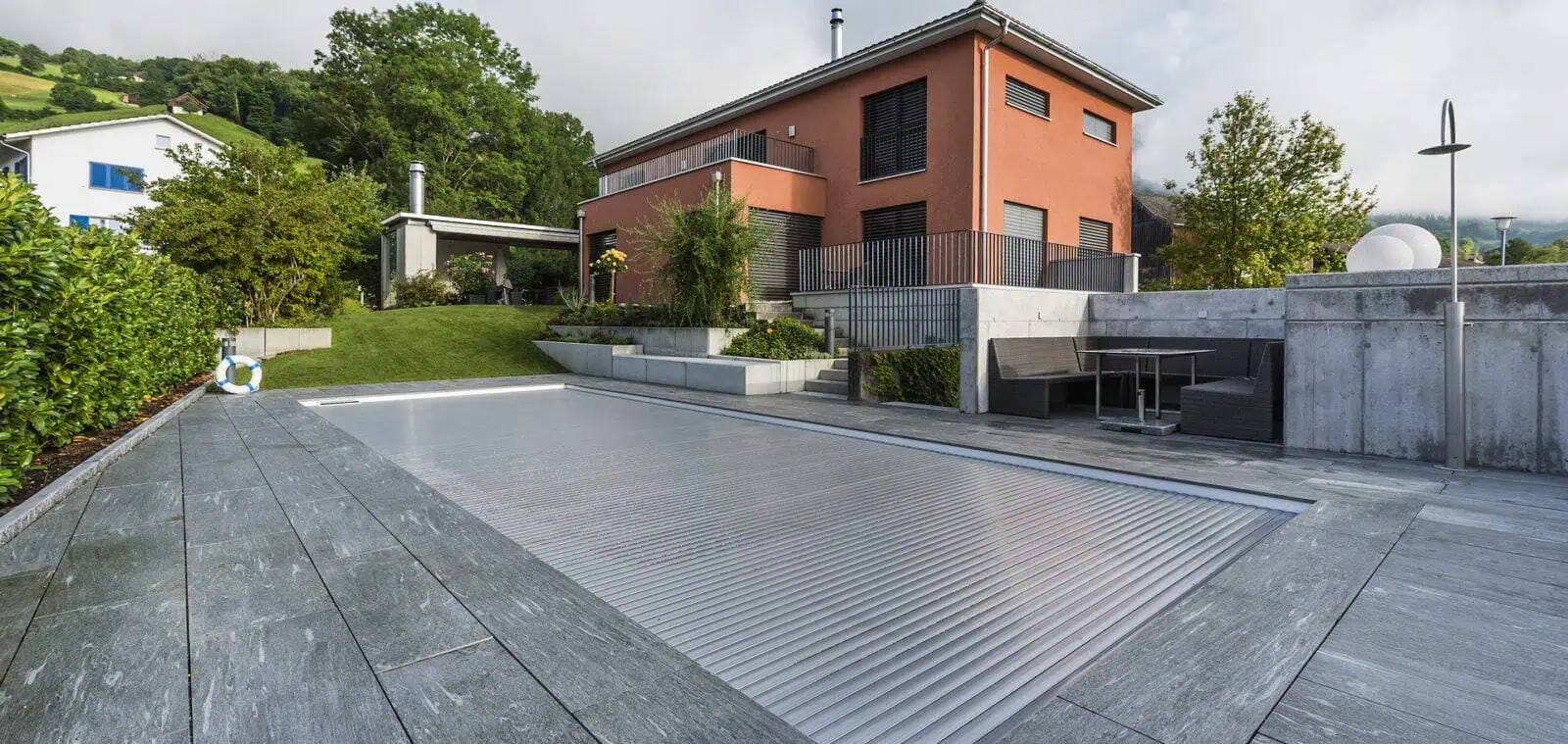 Robuster, hochwertiger Schwimmbadabdeckungs-Rollmechanismus mit deutscher Technik auf einem modernen Pool im Garten.