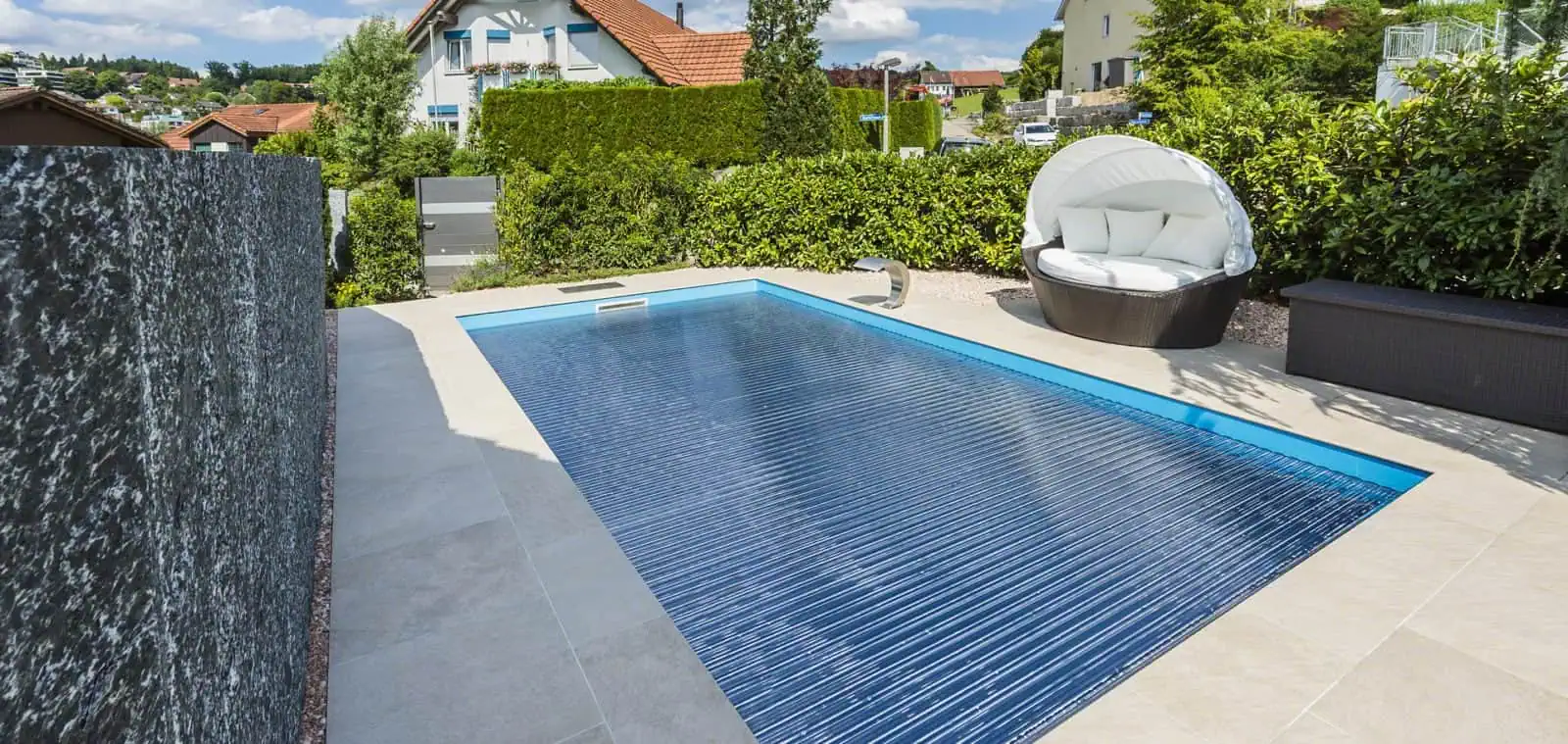 Hochwertiger Poolabdeckungen mit robustem Design vor idyllischer Hausumgebung.